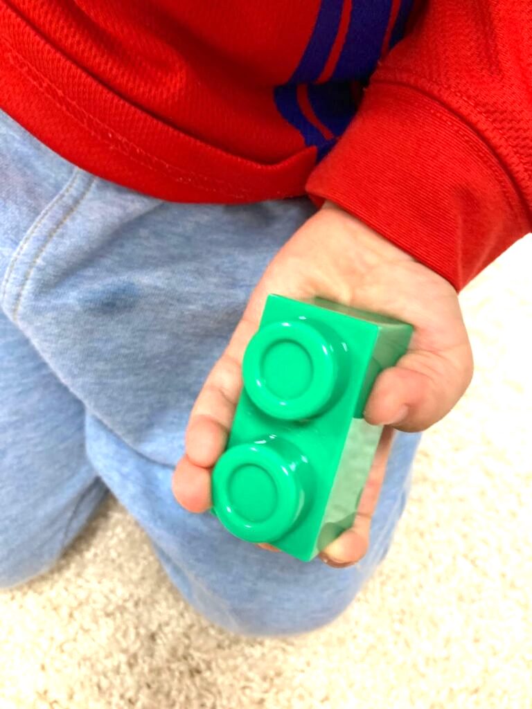 イマジナリウムの「おおきなブロック ボールがコロコロ ボックスセット」のブロックを持つ子供の手