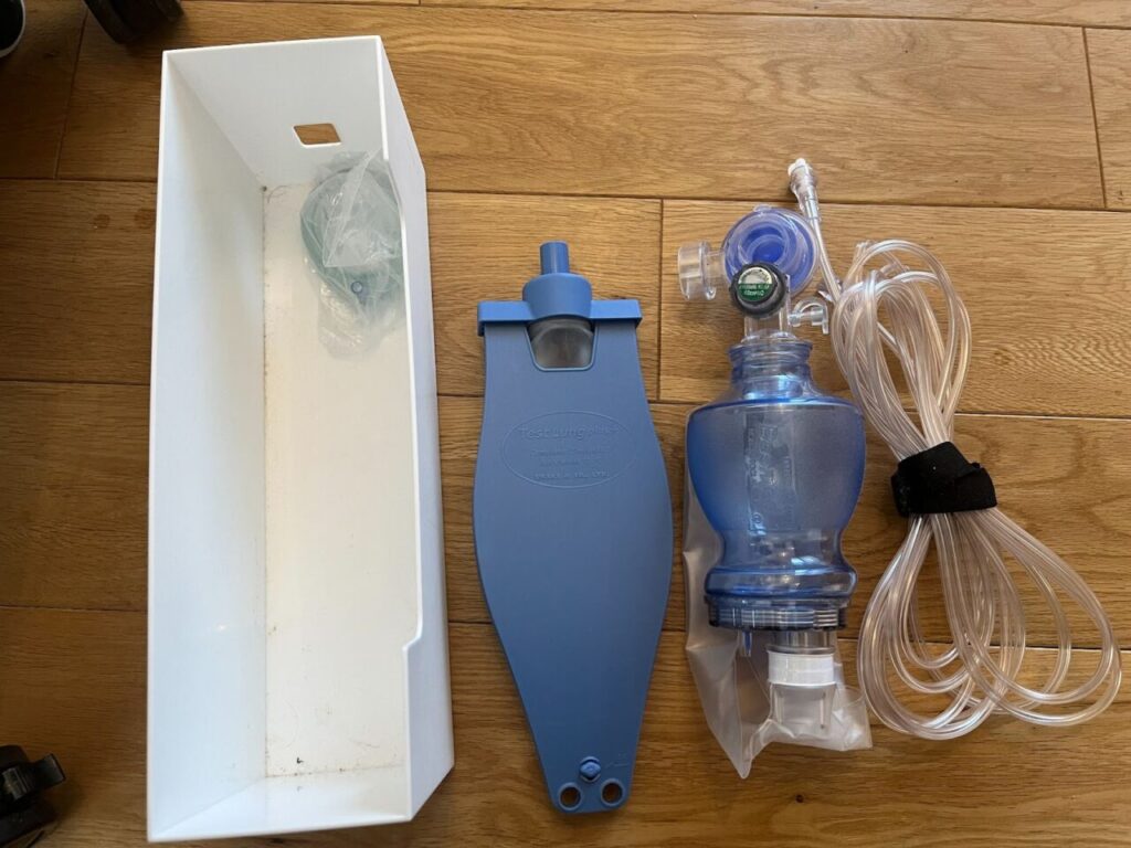 4つの医療機器が並んでいる。左からケース・テスト肺・アンビューバッグ・酸素と人工呼吸器を繋げるチューブ