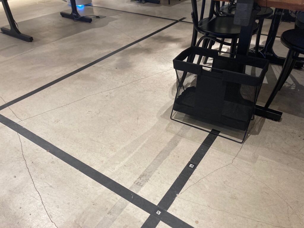 床に貼られた黒いラインとQRコード