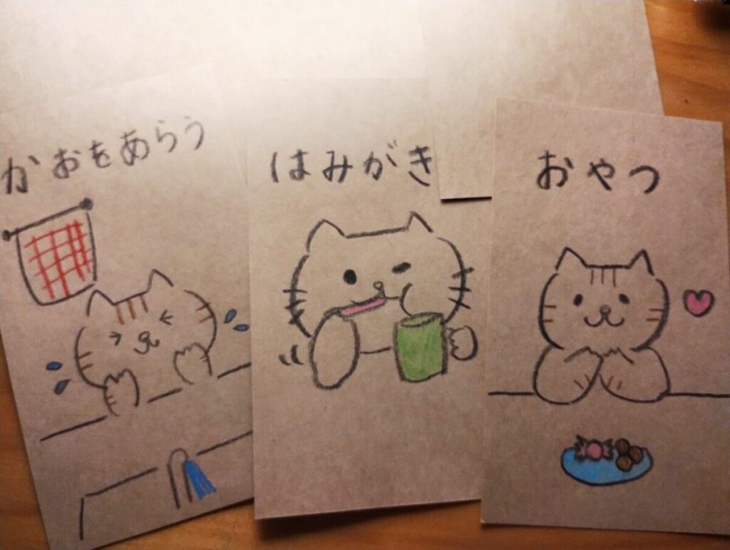 猫のイラストで日常動作が表現してある絵カード。「かおをあらう」「はみがき」「おやつ」の内容