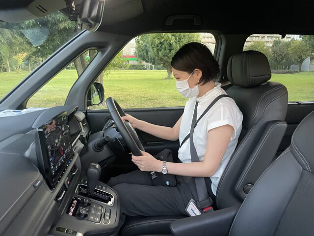 ステップワゴンの運転席に筆者が座ってハンドルを握っている様子