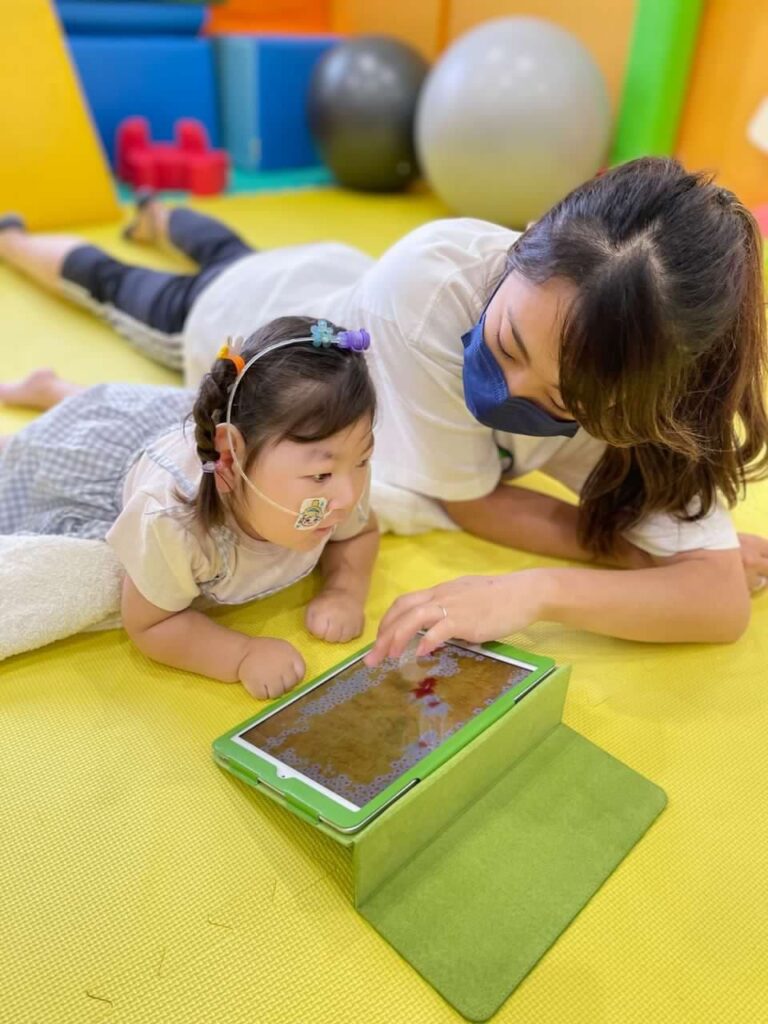 うつぶせで遊びながらリハビリを受ける子ども