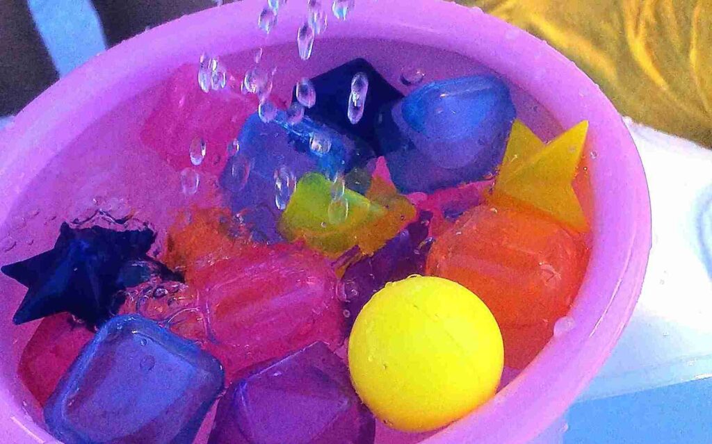 夏の感覚統合遊びで水遊びをしているところ。洗面器に水を溜めてさまざまな硬さのおもちゃを浮かべている様子