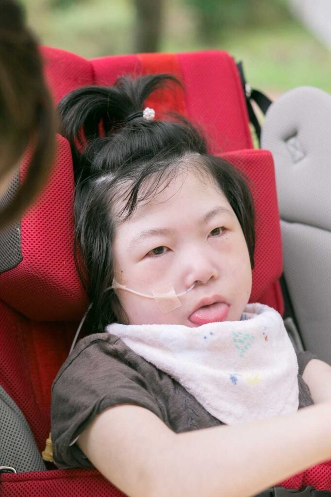 子供用車いすに座っている女の子