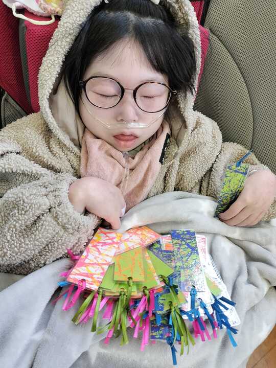 プレゼント用の手作りの栞をたくさん持っている女の子