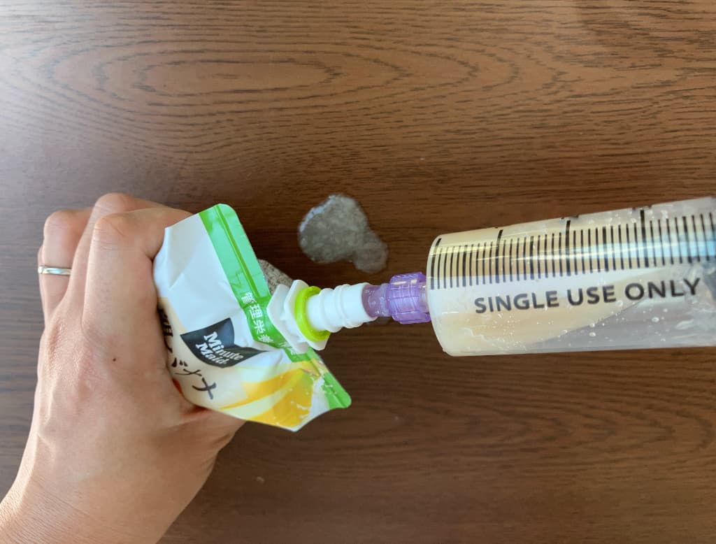 試しにコネクタを使わずにパウチの飲み口に注入用シリンジの先を突っ込んでゼリー飲料を吸い上げ。飲み口の隙間から飲料がこぼれたり、空気ばかり吸い込んだりして、なかなかうまく吸えてない様子