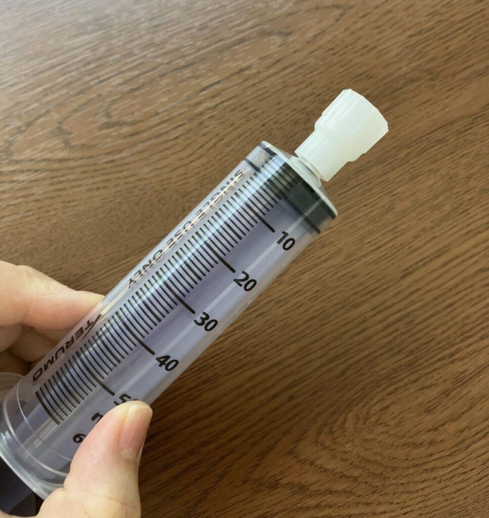コネクタを50mlの注入用シリンジに接続しているところ。
