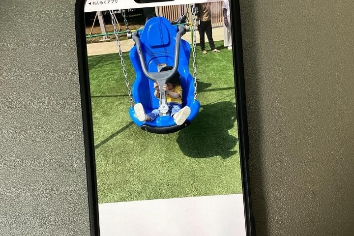 子どもがブランコに乗っている写真。連絡帳アプリでは写真も共有できるという証拠