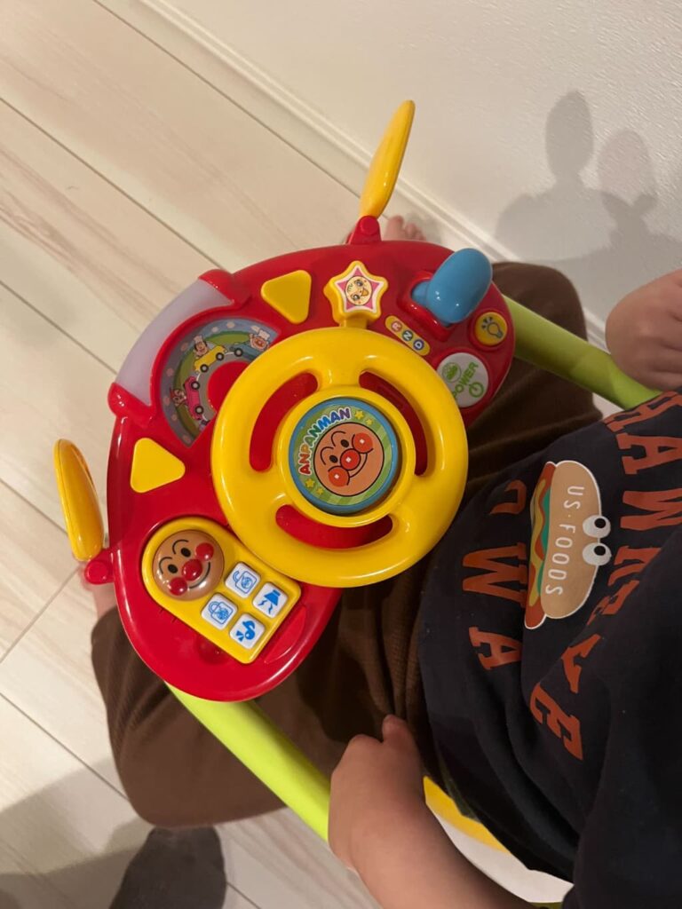 アンパンマンの顔のついた丸いハンドルの右側に水色のレバー、「記号のついたボタンが並んでいる