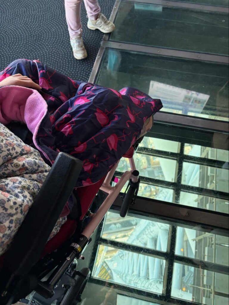 東京スカイツリーのガラス床から下の景色をのぞき込む車いすの子ども