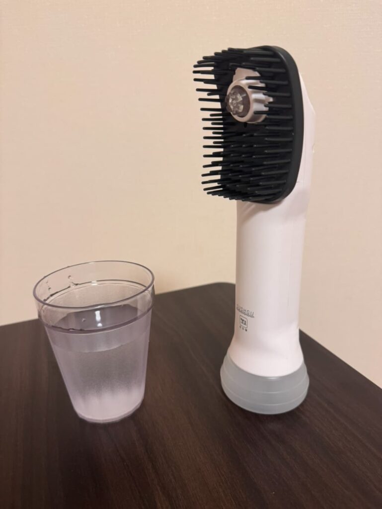 テーブルの上に置かれたSUSUGU本体と水の入ったコップ。