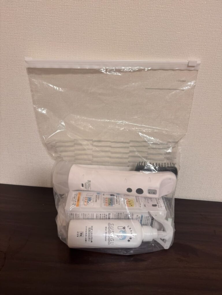 透明のジッパーバッグにSUSUGU本体とミストシャンプー、外箱がまとめて収納されている様子。