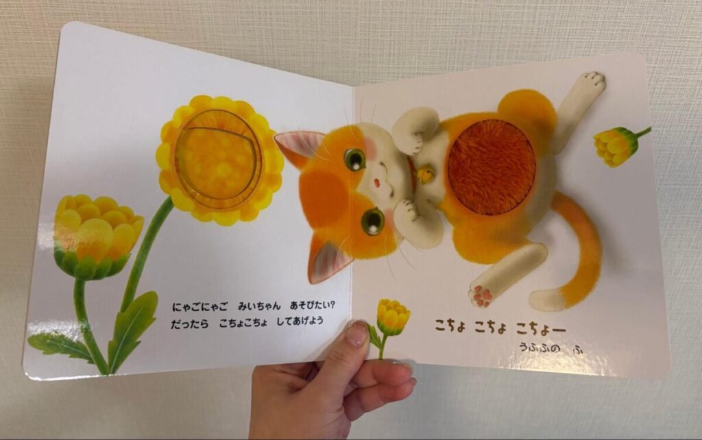 猫のお腹部分にふわふわ素材のしかけがついた、触って楽しめる絵本のページ