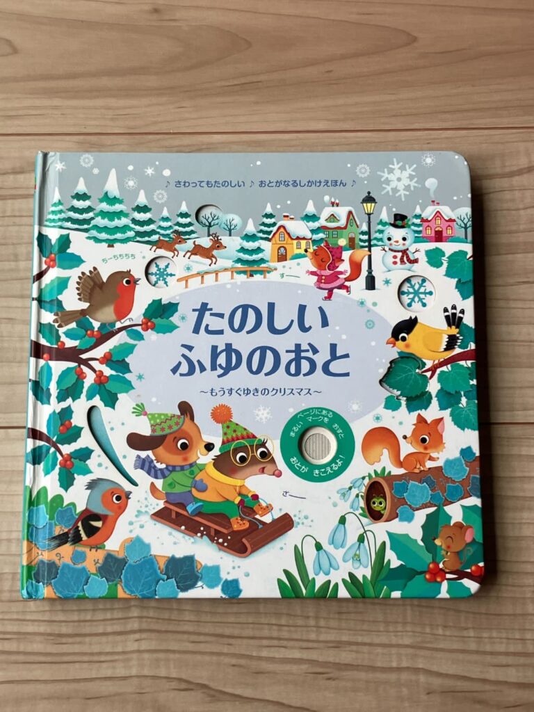 雪景色の動物たちが描かれた「たのしいふゆのおと」の絵本の表紙。マークを推すと音が鳴るというしかけの説明も記載されている。