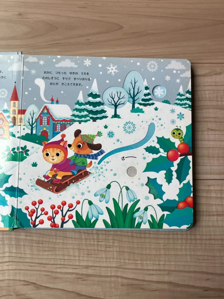 雪景色の中で動物たちがそり遊びをしている、音が鳴るしかけ絵本のページ
