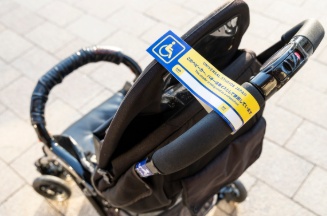 USJで車椅子として利用していることを示す「ベビーカータグ」が取り付けられたベビーカー